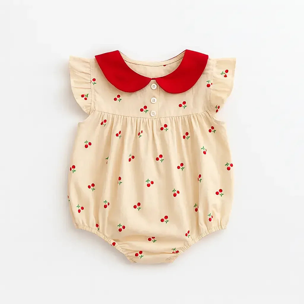 Body feminino para bebê bege com estampa de cerejinhas, gola peter pan vermelha, botões frontais e mangas curtas com babadinhos.