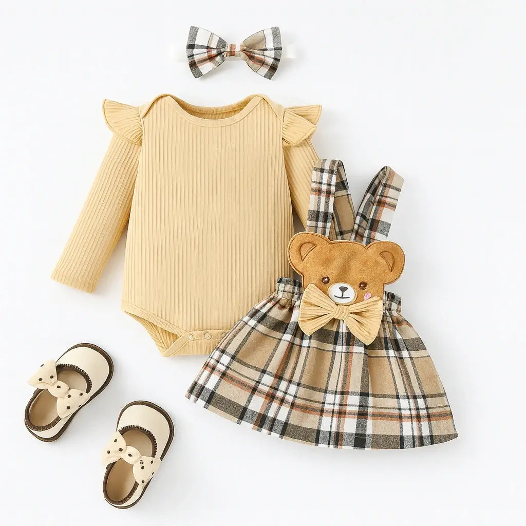Conjunto infantil feminino com body bege de manga longa, saia xadrez com detalhe de ursinho e laço, faixa de cabelo combinando e sapatinhos bege
