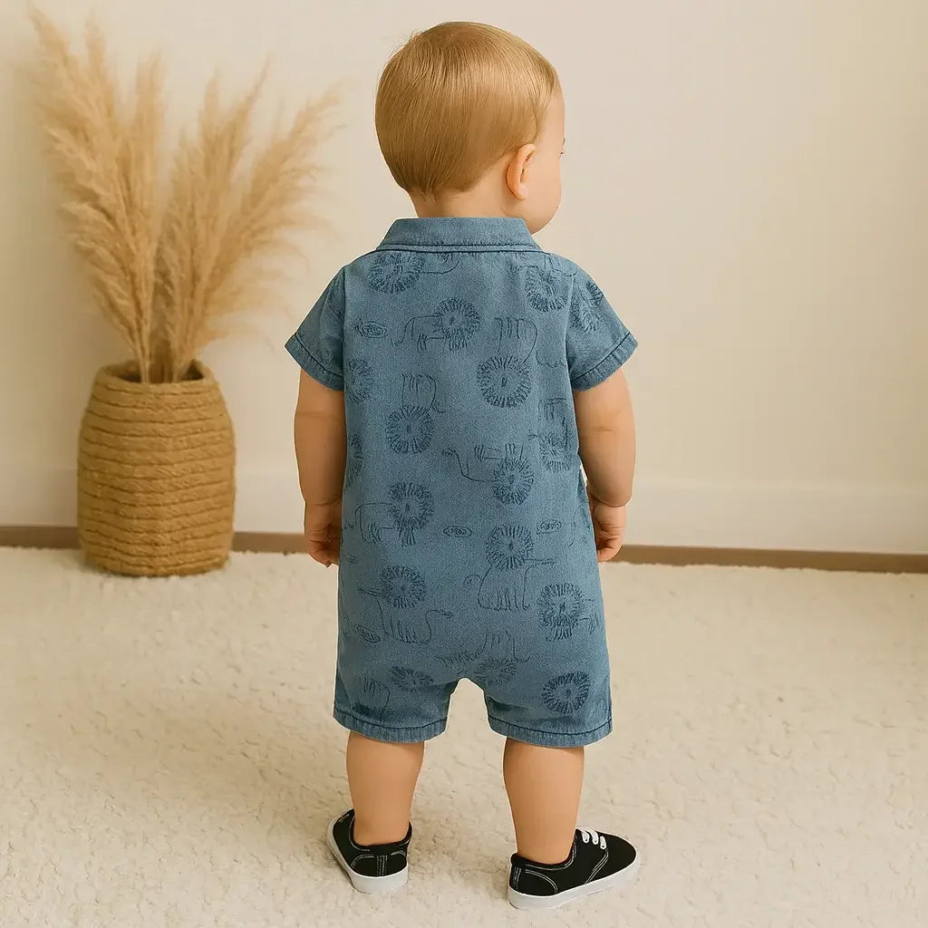 Bebê menino loiro visto de costas, vestindo macacão jeans azul com estampa de leões e sapatos pretos, em pé sobre tapete claro em ambiente aconchegante.