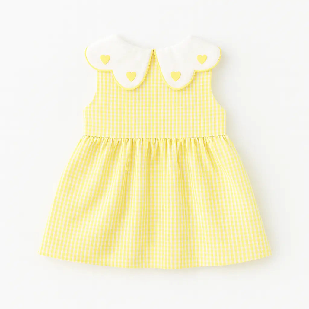 Costas do vestido infantil xadrez amarelo, sem mangas, gola branca com corações e saia franzida.