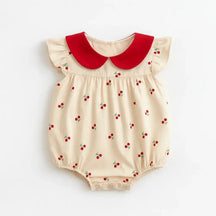 Body infantil feminino bege com estampa de cerejinhas vermelhas, gola peter pan vermelha e mangas curtas com babados.