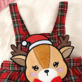 Conjunto infantil feminino composto por body vermelho canelado de manga longa com babadinhos nos ombros e jardineira xadrez vermelha com alças e aplique de rena com laço. A peça está disposta sobre fundo branco, com destaque para o visual natalino e delicado.