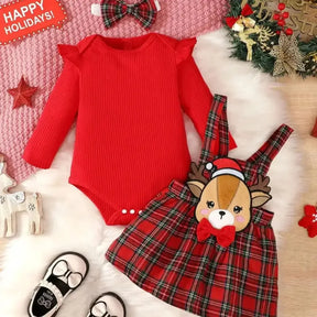 Conjunto infantil feminino composto por body vermelho canelado de manga longa com babadinhos nos ombros e jardineira xadrez vermelha com alças e aplique de rena com laço. A peça está disposta sobre fundo branco, com destaque para o visual natalino e delicado.
