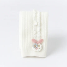 Meia-calça infantil canelada branca com babado lateral e aplique de coelhinho