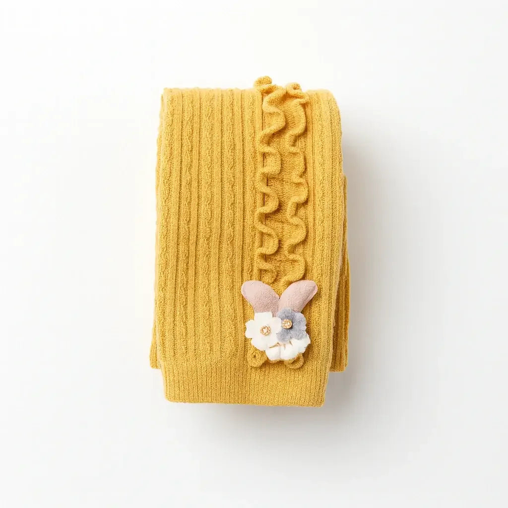 Meia-calça infantil canelada mostarda com babado lateral e aplique de coelhinho