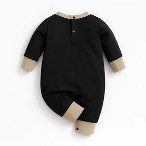 Macacão de bebê menino urso fofo preto e bege visto de costas com brinquedo e tênis