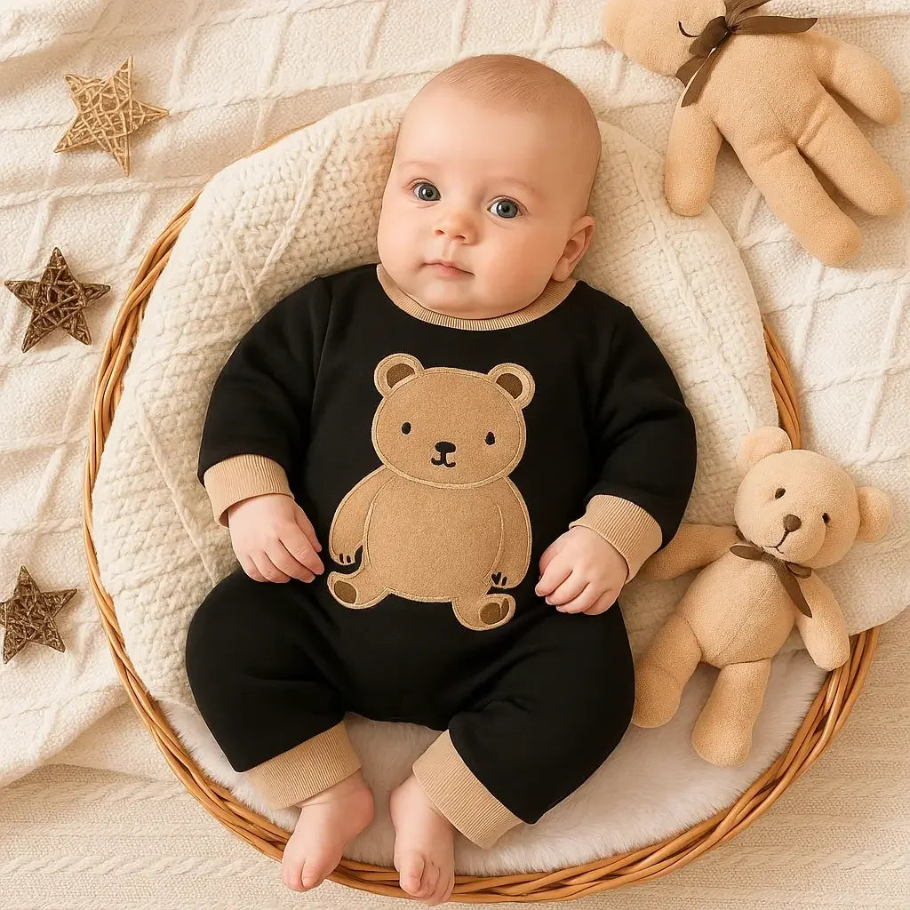 Bebê de 4 meses em cesta aconchegante, usando macacão preto com ursinho bege – moda infantil Baby Hello