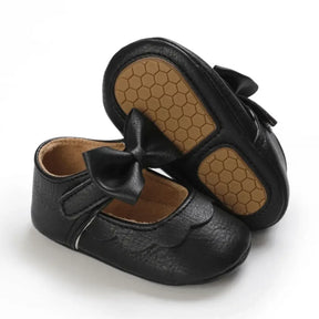 Sapato preto para bebê primeiros passos em couro macio, com laço delicado e sola antiderrapante.