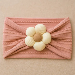 Turbante rosa para bebê com flor de tecido bege no centro, acessório delicado, elástico e confortável para meninas de 0 a 18 meses.