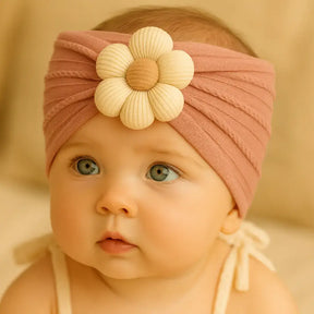 Bebê usando turbante rosa com flor de tecido no centro, acessório delicado e confortável para meninas de 0 a 18 meses