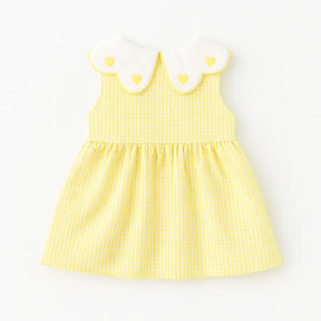 Costas do vestido infantil xadrez amarelo, sem mangas, gola branca com corações e saia franzida.