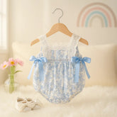 romper bebê azul com detalhes em renda e laços delicados, moda infantil boutique em fundo clean